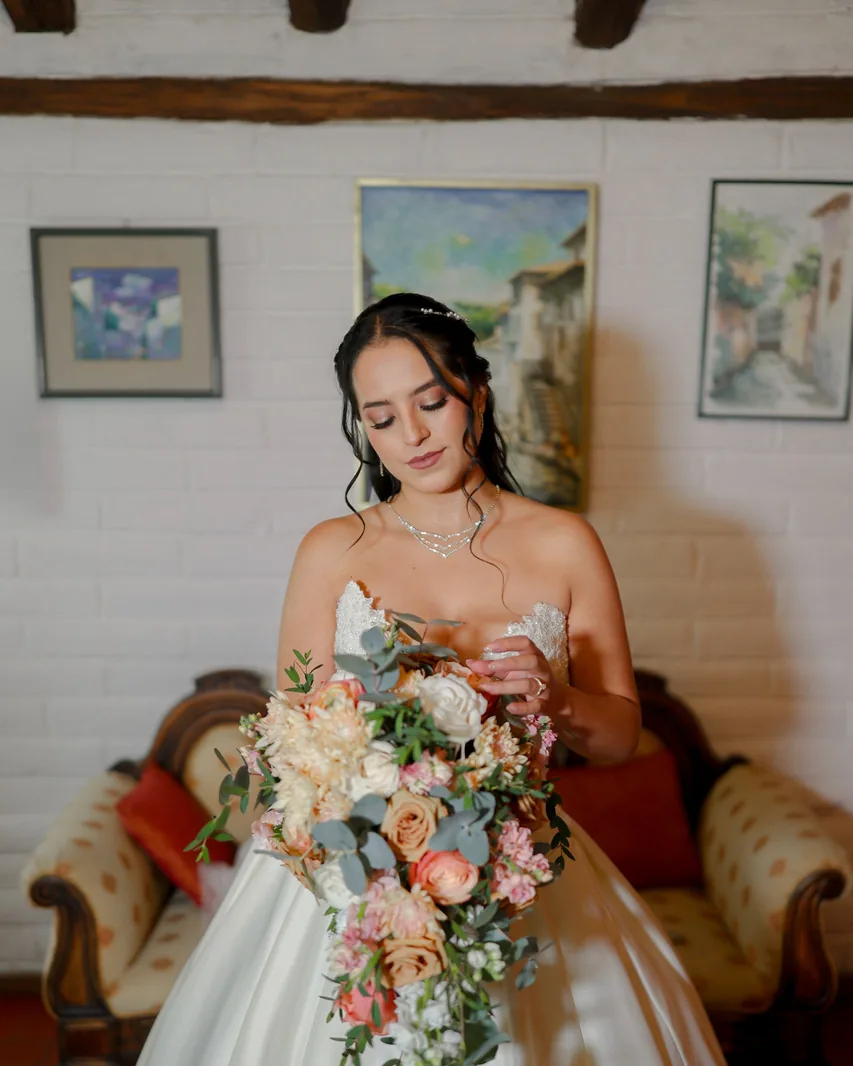 Novia posando con ramo de flores en tonos durazno